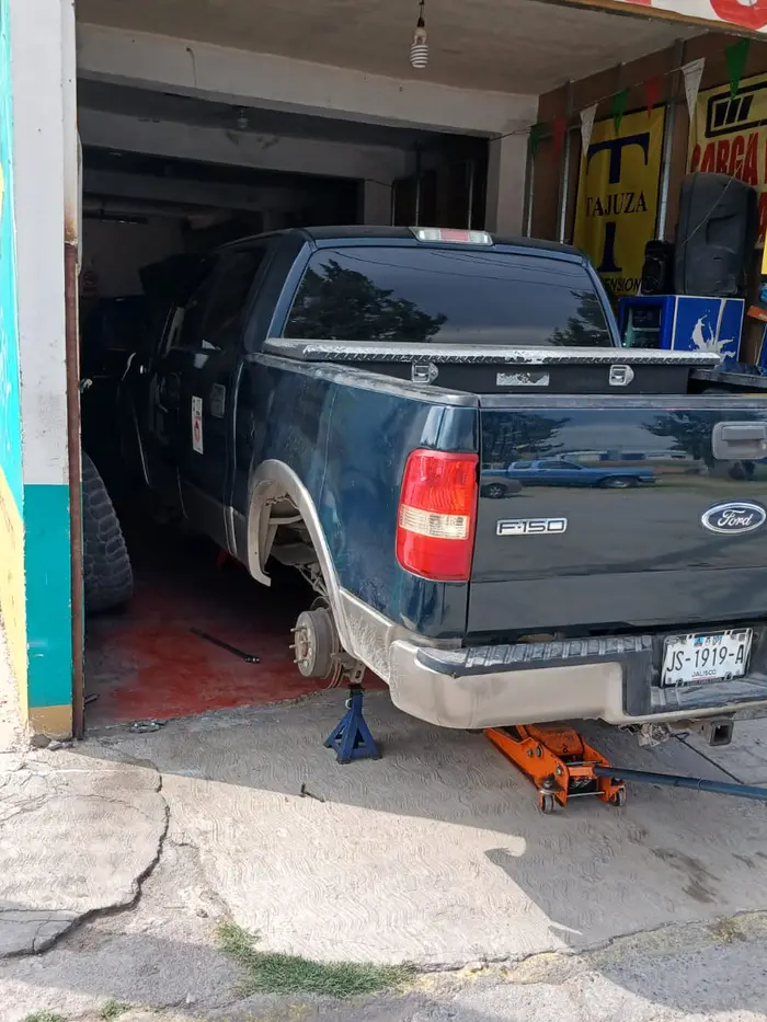 Entrada del taller Tajuza en Blvd. Antonio Cárdenas, con una camioneta en reparación de frenos
